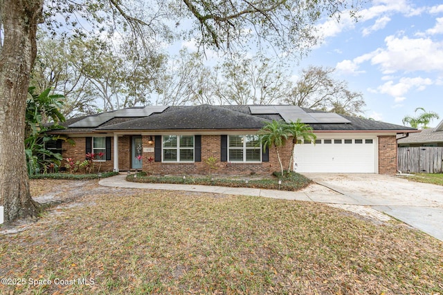 single story home featuring an attached garage, brick siding, fence, concrete driveway, and a front lawn