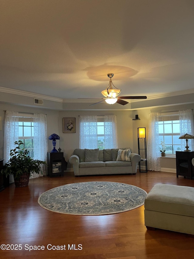 living room with ornamental molding, ceiling fan, plenty of natural light, and wood-type flooring