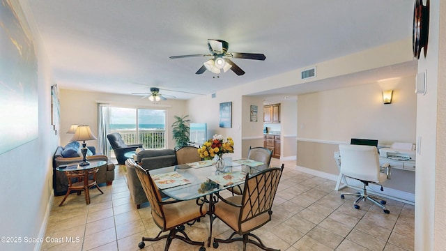 dining room with a ceiling fan, visible vents, baseboards, and light tile patterned floors