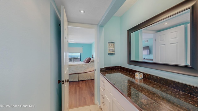 bathroom featuring tile patterned flooring, ensuite bath, and vanity