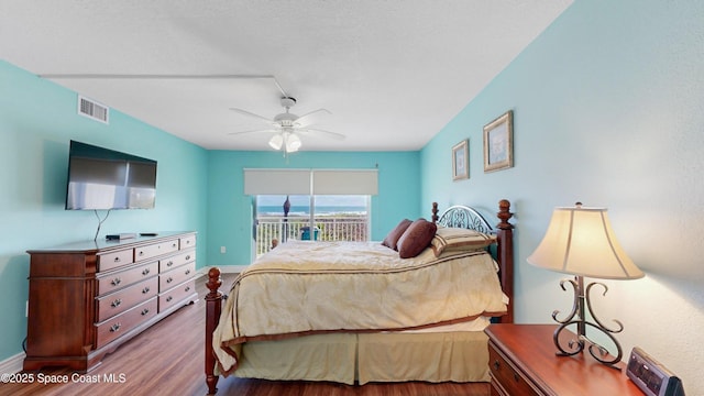 bedroom with visible vents, baseboards, ceiling fan, wood finished floors, and access to exterior