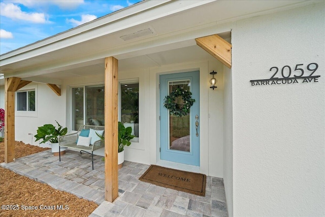 property entrance with stucco siding