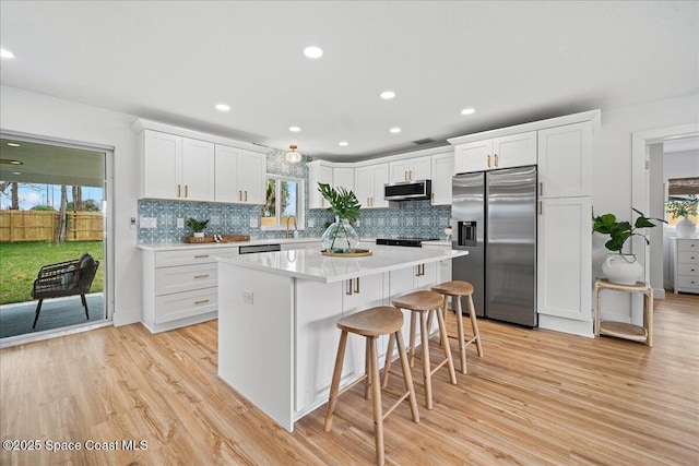 kitchen featuring light countertops, appliances with stainless steel finishes, and white cabinetry