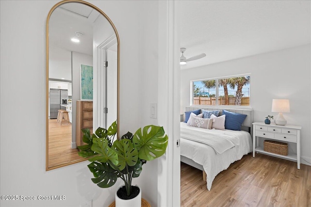 bedroom featuring light wood finished floors, ceiling fan, and built in fridge