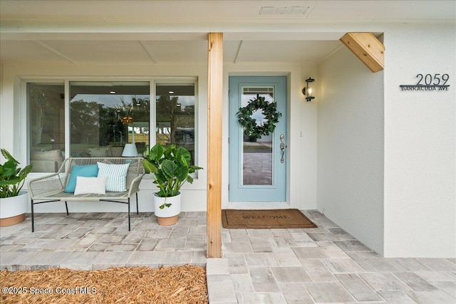 entrance to property featuring stucco siding