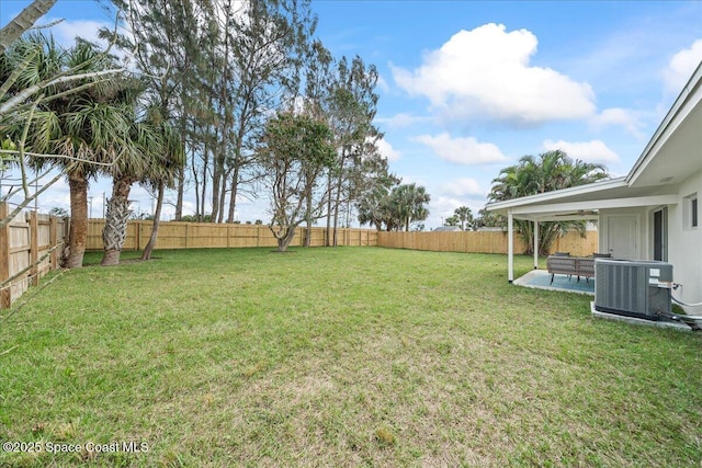 view of yard featuring a patio, a fenced backyard, and central air condition unit