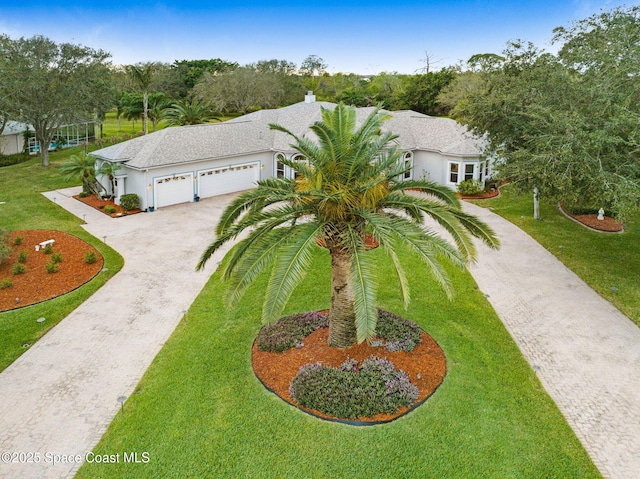 view of front of property featuring a garage, driveway, and a front lawn