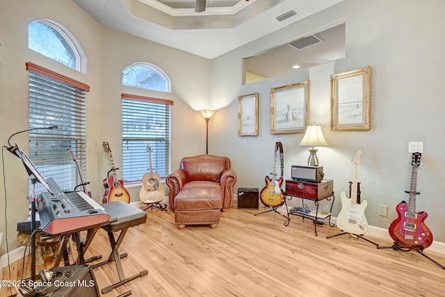 living area featuring light wood-style floors, visible vents, plenty of natural light, and baseboards