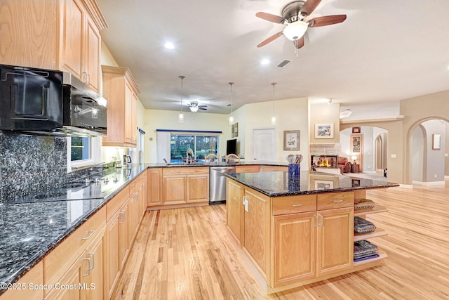 kitchen with dark stone countertops, open floor plan, dishwasher, and a center island