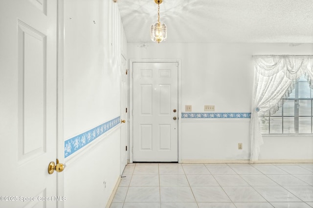 tiled foyer with a textured ceiling