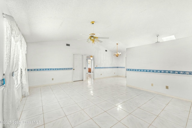 unfurnished room with a textured ceiling, lofted ceiling, light tile patterned floors, and ceiling fan with notable chandelier