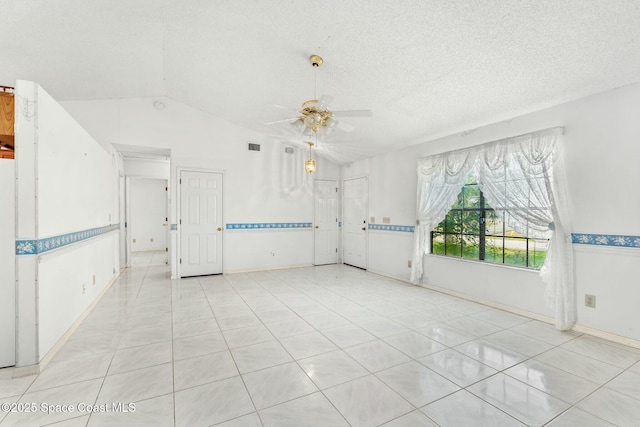 unfurnished room with ceiling fan, light tile patterned floors, a textured ceiling, and lofted ceiling