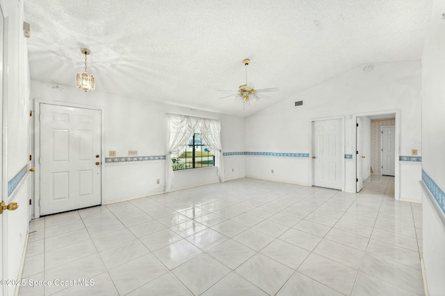 tiled entryway featuring ceiling fan, a textured ceiling, and lofted ceiling