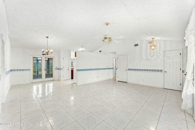 spare room with french doors, a textured ceiling, light tile patterned flooring, vaulted ceiling, and ceiling fan with notable chandelier