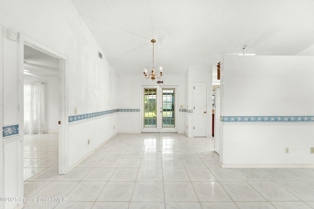 unfurnished room with light tile patterned floors, a chandelier, vaulted ceiling, a textured ceiling, and french doors