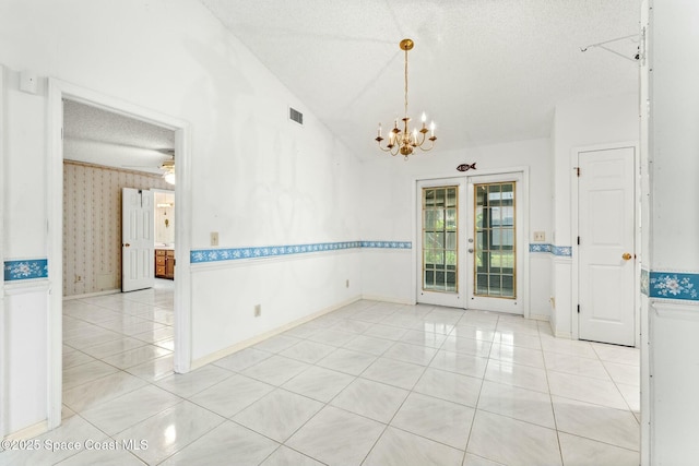 tiled spare room with french doors, vaulted ceiling, an inviting chandelier, and a textured ceiling