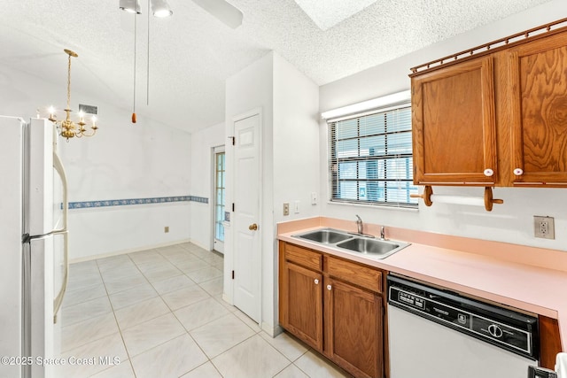 kitchen with white appliances, light tile patterned floors, sink, lofted ceiling, and pendant lighting