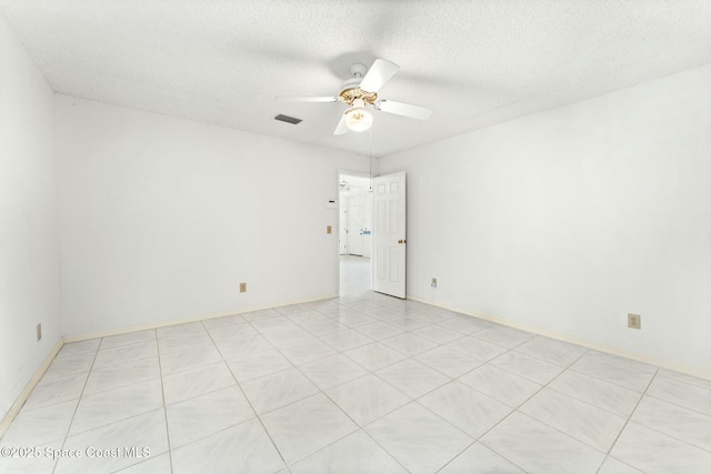 unfurnished room with ceiling fan and a textured ceiling