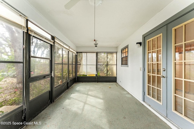 unfurnished sunroom with ceiling fan and a healthy amount of sunlight