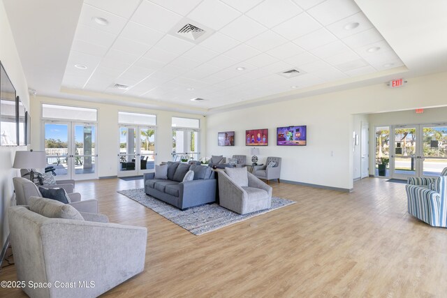 4179 Keeson Cir, Vero Beach, FL 32967 - living area featuring a tray ceiling, french doors, light wood-type flooring, and baseboards