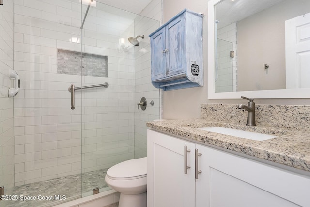 full bath with vanity, toilet, and a shower stall