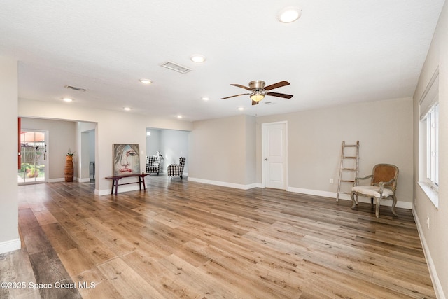 sitting room featuring baseboards, visible vents, and light wood-style floors