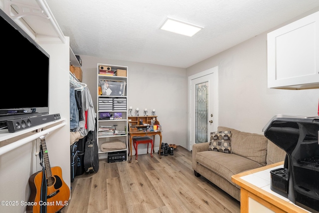 living room with light wood-style flooring and a textured ceiling