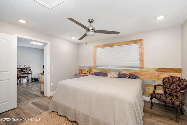 bedroom with a textured ceiling, recessed lighting, and wood finished floors