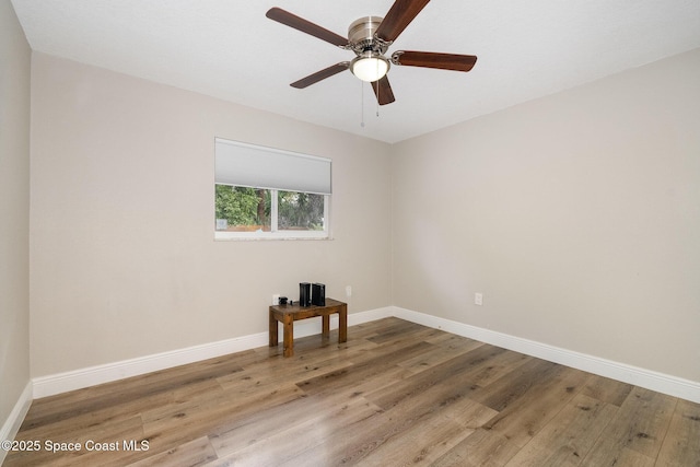 empty room featuring baseboards, a ceiling fan, and wood finished floors