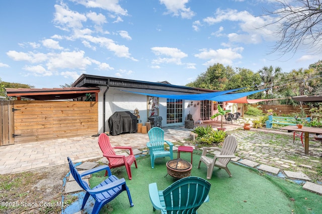 view of patio / terrace with fence, grilling area, and a fire pit