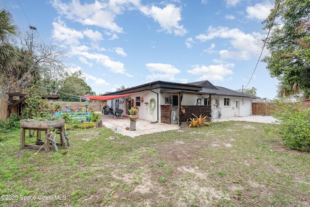 back of property featuring a lawn, a patio area, and fence