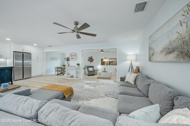 living room featuring visible vents and light wood-style flooring