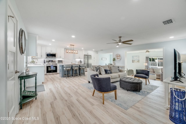 122 Poinsetta St, Indialantic, FL 32903 - living room featuring light wood-style floors, a ceiling fan, recessed lighting, and a chandelier