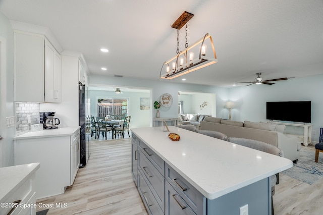 122 Poinsetta St, Indialantic, FL 32903 - kitchen featuring a ceiling fan, light wood-style flooring, light countertops, a kitchen island, and recessed lighting