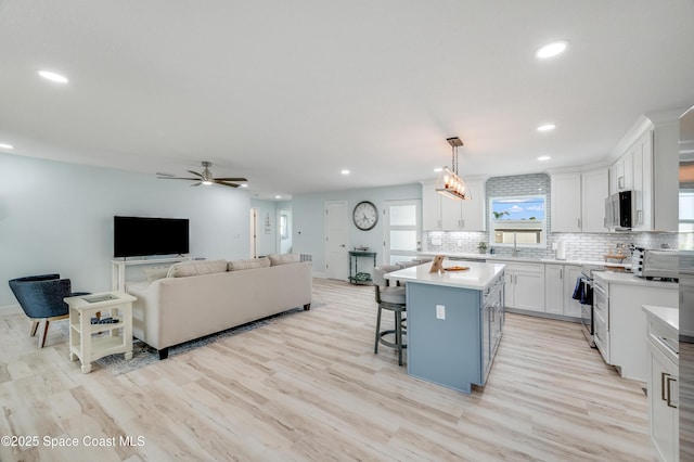 122 Poinsetta St, Indialantic, FL 32903 - kitchen with stainless steel appliances, recessed lighting, decorative backsplash, white cabinets, and light countertops