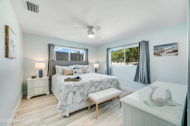 122 Poinsetta St, Indialantic, FL 32903 - bedroom featuring multiple windows, light wood finished floors, a ceiling fan, and a textured ceiling