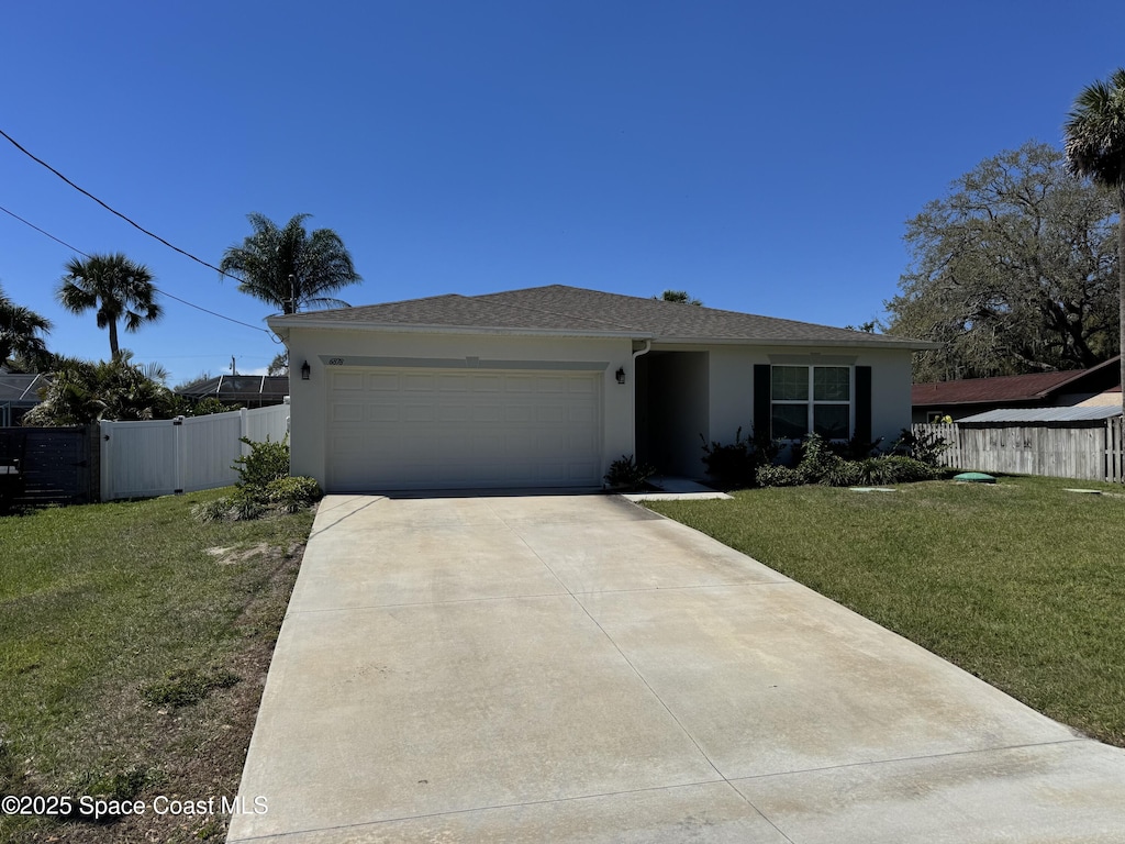 single story home featuring an attached garage, a front yard, a gate, and stucco siding