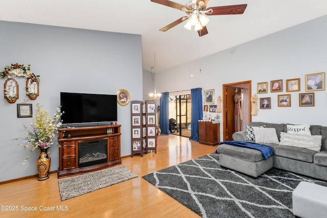 living room featuring hardwood / wood-style flooring, lofted ceiling, and ceiling fan with notable chandelier