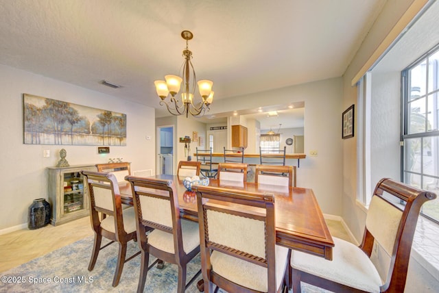 dining area featuring visible vents, a chandelier, and baseboards