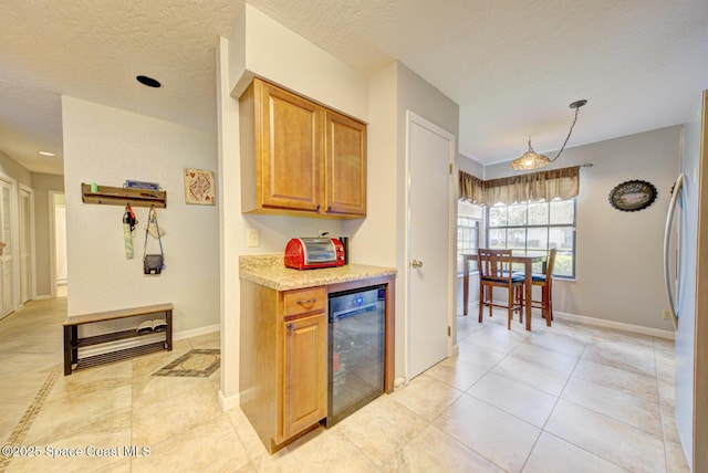 kitchen with beverage cooler, baseboards, light countertops, and freestanding refrigerator