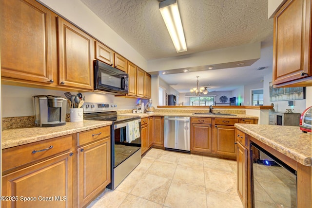 kitchen with wine cooler, light countertops, appliances with stainless steel finishes, brown cabinetry, and a peninsula