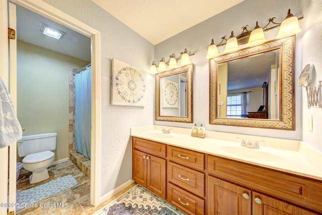 full bathroom featuring double vanity, a sink, toilet, and baseboards