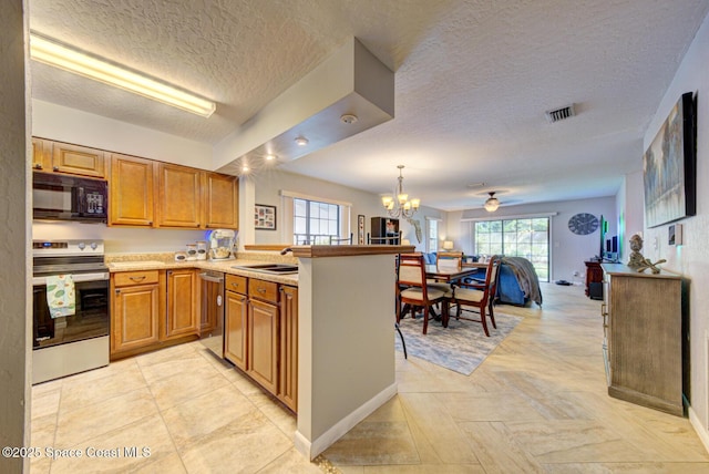 kitchen featuring open floor plan, a peninsula, stainless steel appliances, light countertops, and pendant lighting