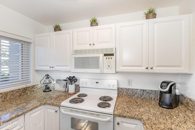 kitchen featuring stone countertops, white appliances, and white cabinets