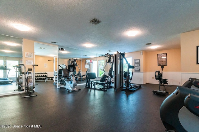 gym with visible vents and a textured ceiling