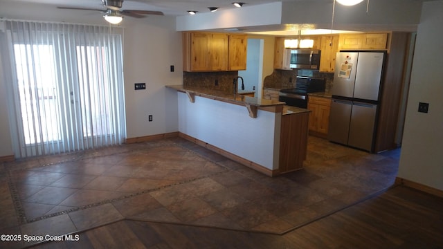 kitchen featuring tasteful backsplash, baseboards, ceiling fan, a peninsula, and stainless steel appliances