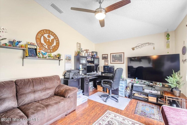 home office featuring visible vents, ceiling fan, wood finished floors, vaulted ceiling, and a textured ceiling