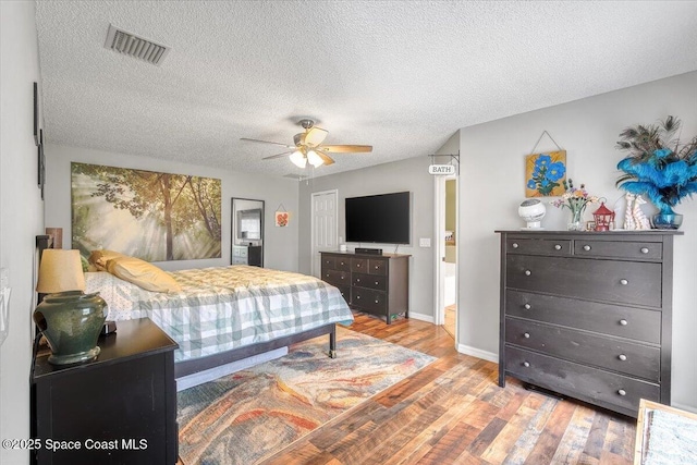 bedroom with visible vents, ceiling fan, a textured ceiling, and light wood finished floors