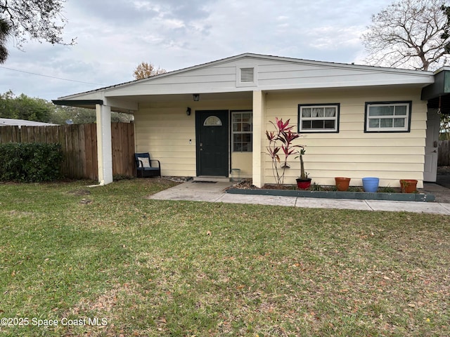 view of front of home with fence and a front lawn