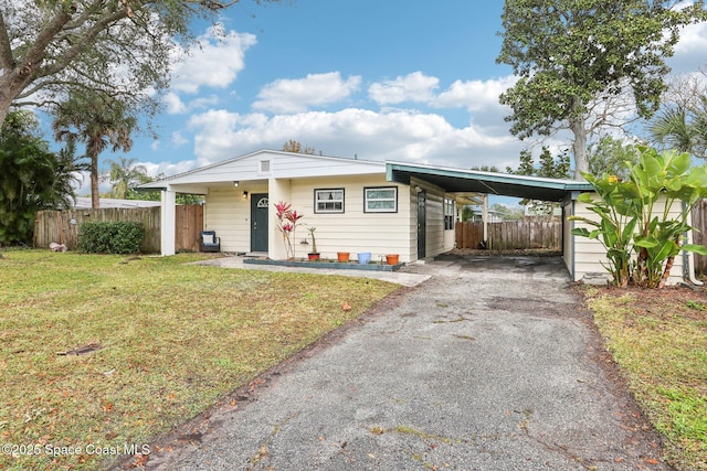 view of front of home featuring fence, a front lawn, aphalt driveway, and an attached carport